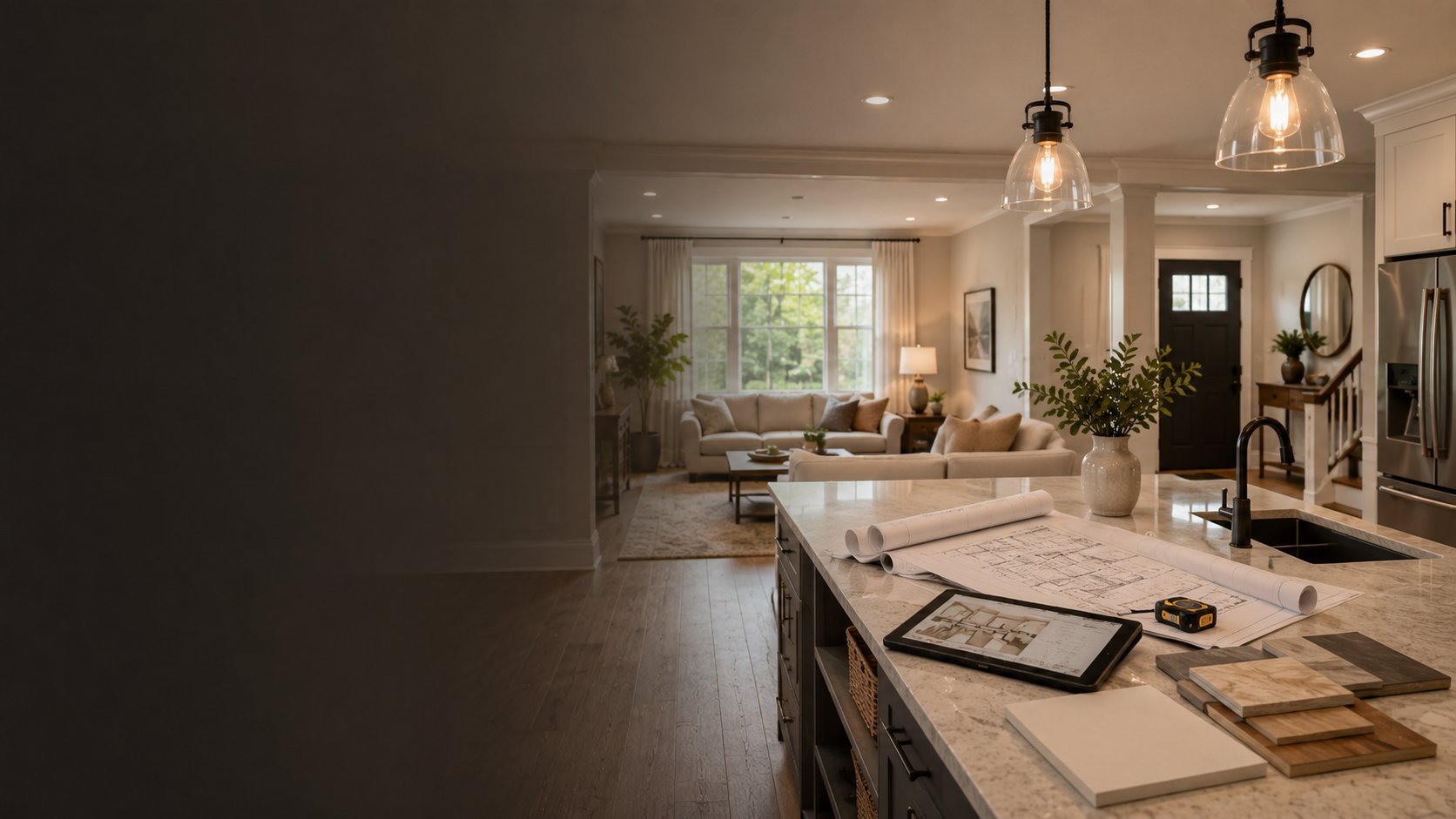 Modern kitchen and living room with granite island, pendant lights, and open floor plan leading to furnished living space
