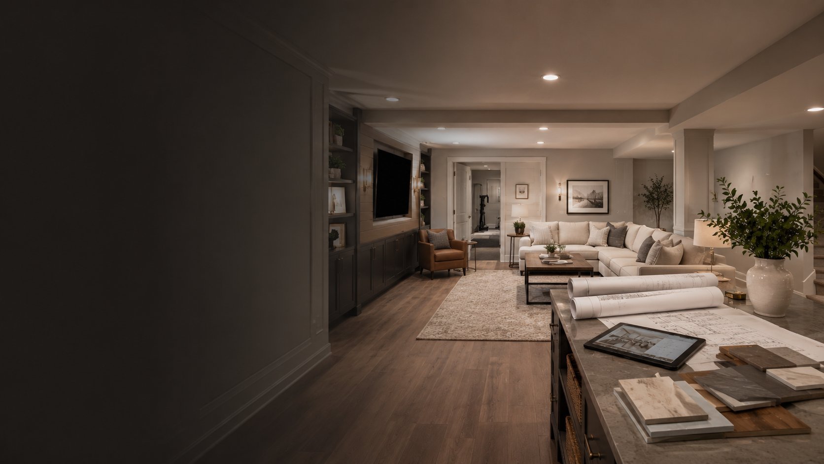 Modern open-concept apartment interior with kitchen counter in foreground, living room with neutral furniture and area rug in background, warm lighting throughout